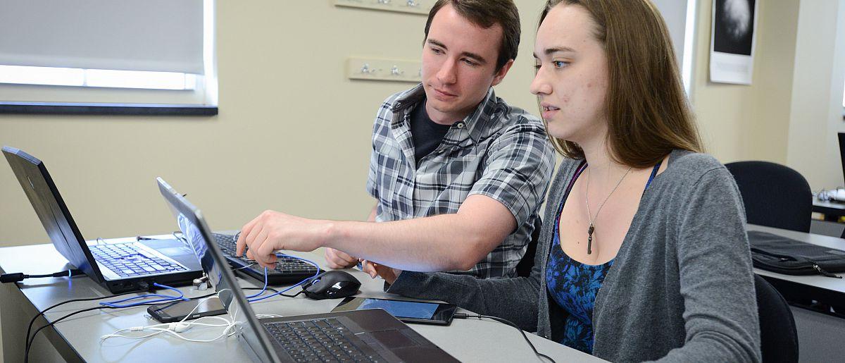 Two students looking at a computer screen.